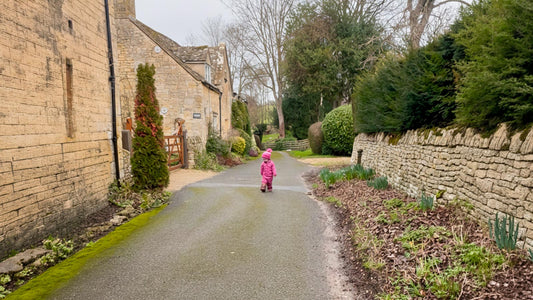 Child In Raincoat Walking Along A Path In The Cotswolds